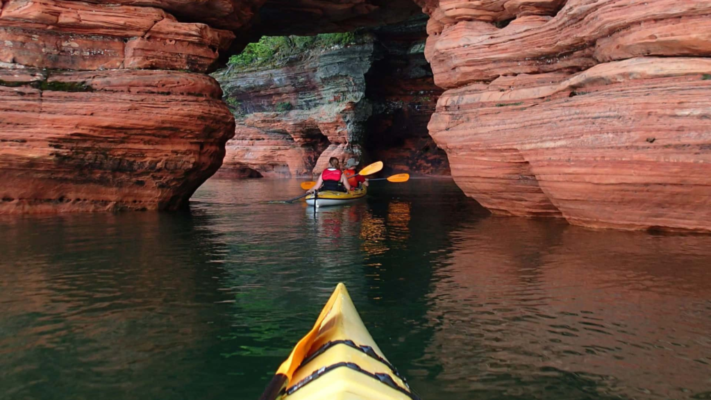 Revelers savoring the fall scenery around Lake Superior, cycling, ATVing, and kayaking amidst the vibrant foliage.